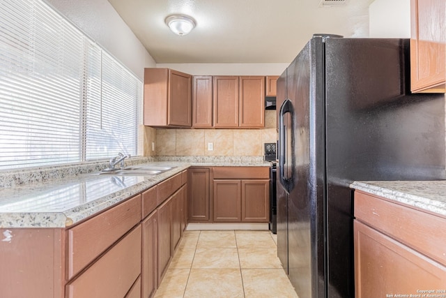 kitchen featuring black fridge, sink, light tile patterned floors, tasteful backsplash, and electric range oven