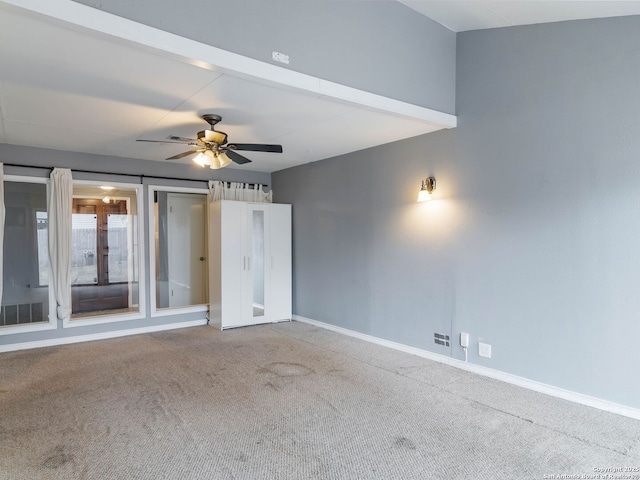 carpeted spare room featuring ceiling fan