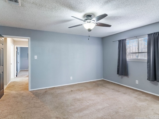 carpeted empty room with a textured ceiling and ceiling fan