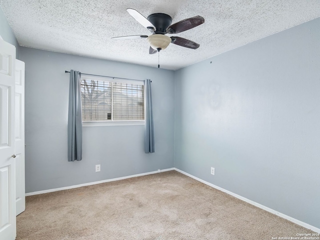 unfurnished room featuring a textured ceiling, ceiling fan, and light carpet