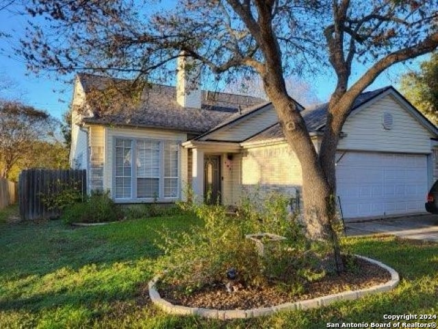 single story home featuring a garage and a front yard