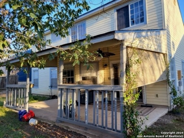 rear view of property with ceiling fan and a deck