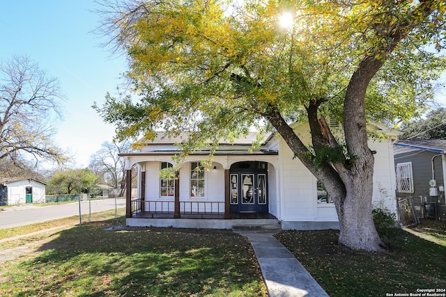 view of front of house with a porch and a front yard