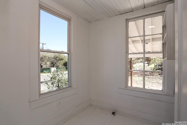 empty room featuring a healthy amount of sunlight and wooden ceiling