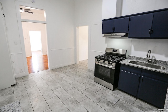 kitchen with blue cabinetry, stainless steel gas stove, ceiling fan, and sink