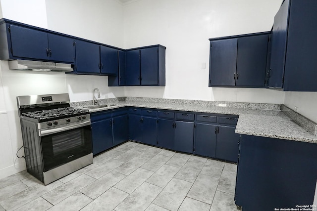 kitchen with blue cabinets, sink, light tile patterned floors, light stone counters, and stainless steel range with gas stovetop