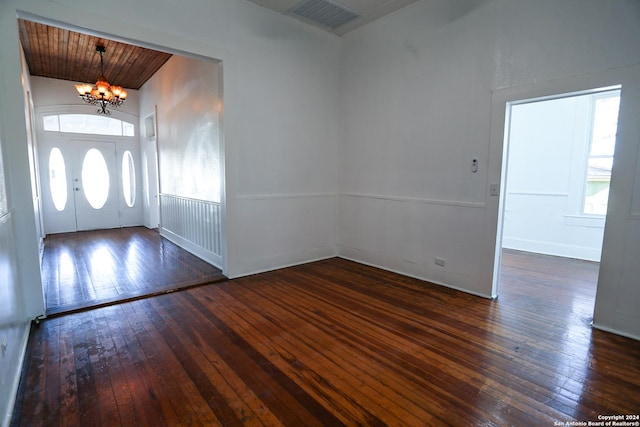 entryway featuring a chandelier, dark wood-type flooring, and wood ceiling