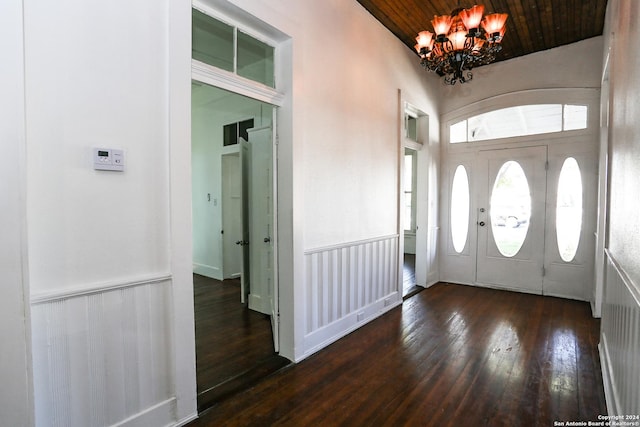 entryway with dark hardwood / wood-style floors, an inviting chandelier, and wooden ceiling