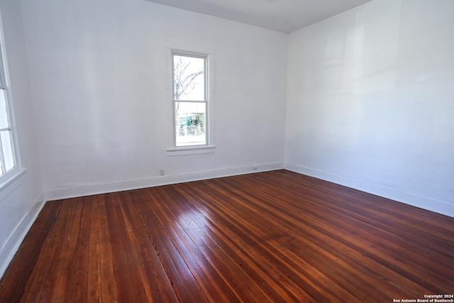 unfurnished room with dark wood-type flooring