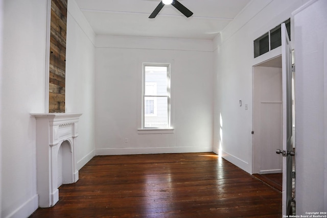 unfurnished living room featuring dark hardwood / wood-style flooring and ceiling fan