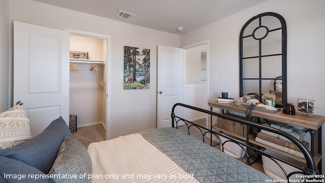 carpeted bedroom featuring a walk in closet and a closet