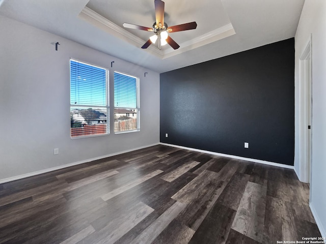 unfurnished room with dark hardwood / wood-style floors, a raised ceiling, ceiling fan, and crown molding