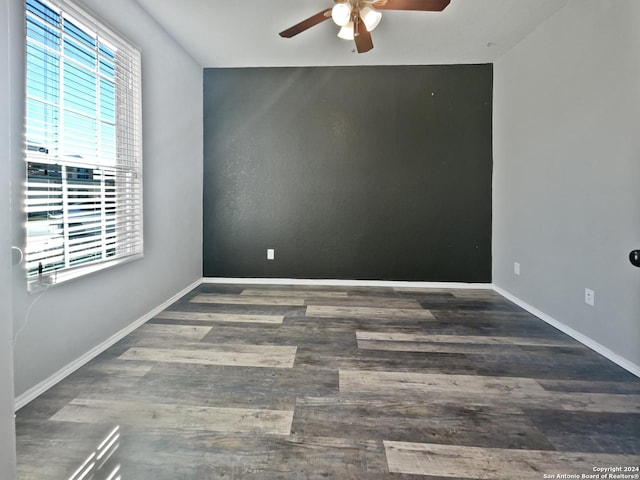 spare room with dark hardwood / wood-style flooring and ceiling fan