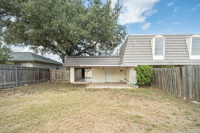 rear view of property featuring a lawn and a patio