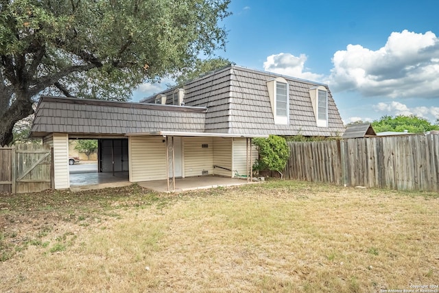 back of house with a yard and a patio