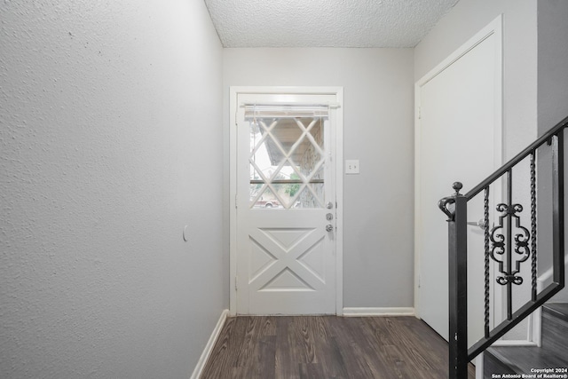 doorway to outside with dark hardwood / wood-style floors and a textured ceiling