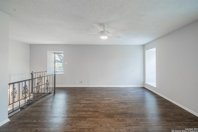 empty room with a textured ceiling, ceiling fan, and dark hardwood / wood-style floors