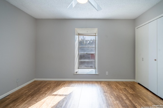 unfurnished bedroom featuring a textured ceiling, hardwood / wood-style flooring, and ceiling fan