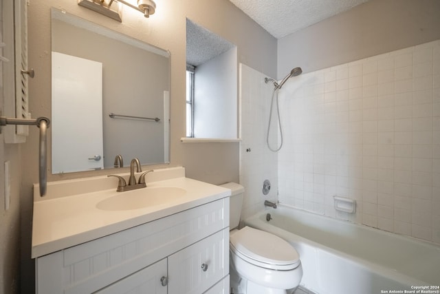 full bathroom with vanity, a textured ceiling, toilet, and tiled shower / bath