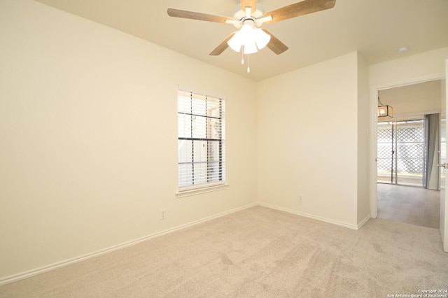 carpeted spare room featuring ceiling fan and a healthy amount of sunlight