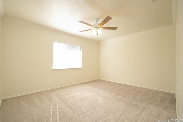 empty room featuring light carpet, crown molding, and ceiling fan