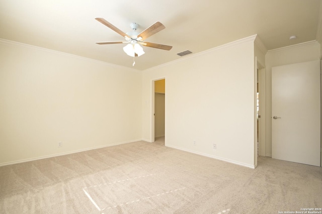 spare room with light carpet, ceiling fan, and crown molding