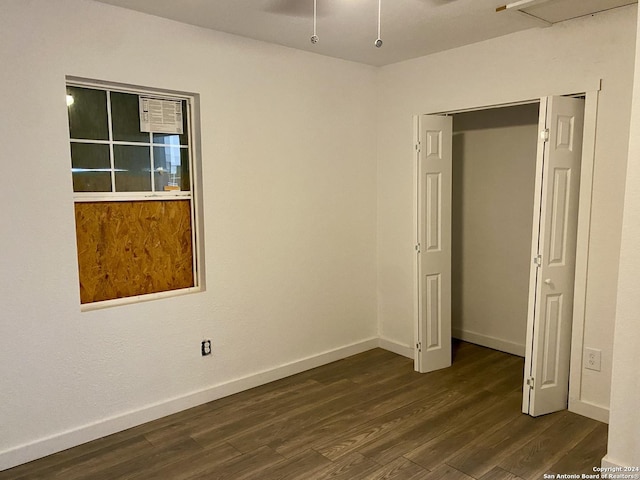 unfurnished bedroom with a closet and dark hardwood / wood-style floors