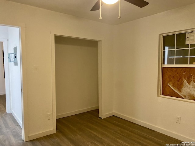 unfurnished bedroom featuring a closet, ceiling fan, and dark hardwood / wood-style flooring