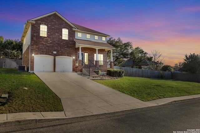 view of front of house featuring a porch, a yard, a garage, and central air condition unit