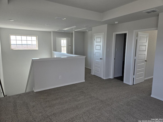 unfurnished room with dark carpet