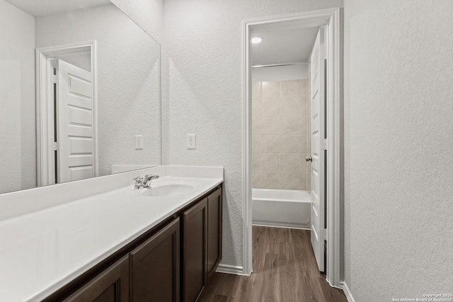 2659 Greenwell Ln, New Braunfels, TX 78130 - full bathroom with wood finished floors, vanity, and a textured wall