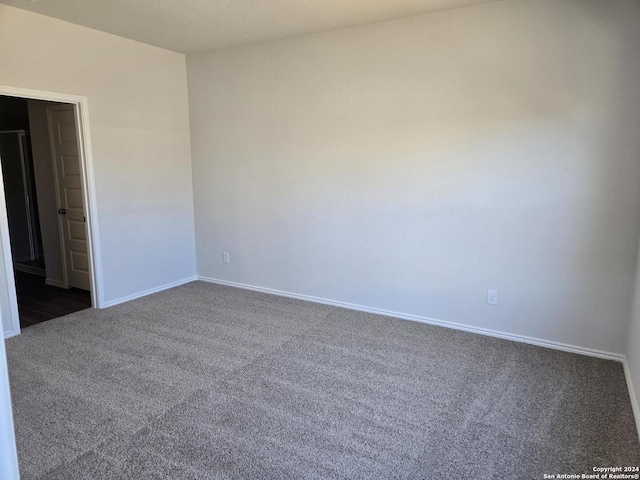 empty room with dark colored carpet