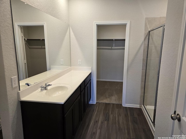 bathroom with vanity, wood-type flooring, and an enclosed shower