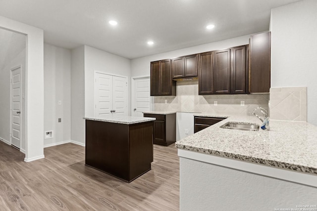 2659 Greenwell Ln, New Braunfels, TX 78130 - kitchen featuring dark brown cabinetry, decorative backsplash, light stone counters, light wood-style floors, and recessed lighting