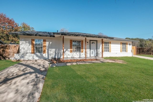 ranch-style home featuring a front lawn and covered porch