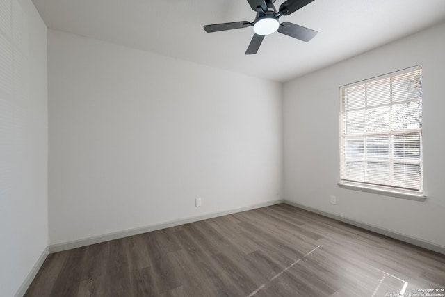 spare room with a wealth of natural light, ceiling fan, and wood-type flooring