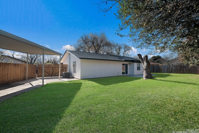 back of property featuring a lawn and cooling unit