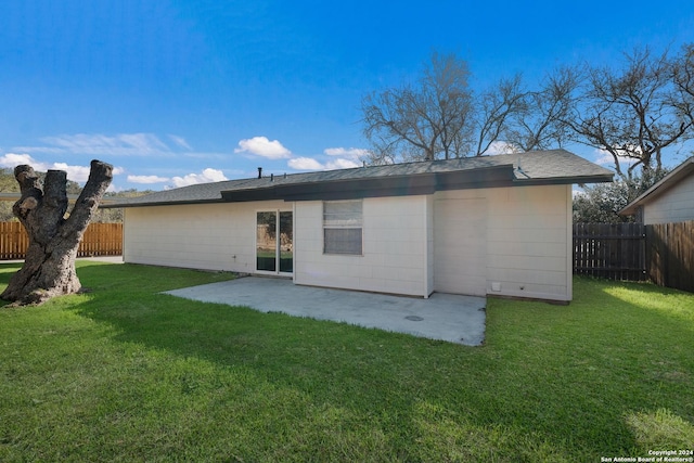 back of house featuring a lawn and a patio area