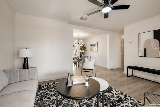 living room featuring hardwood / wood-style floors and ceiling fan with notable chandelier