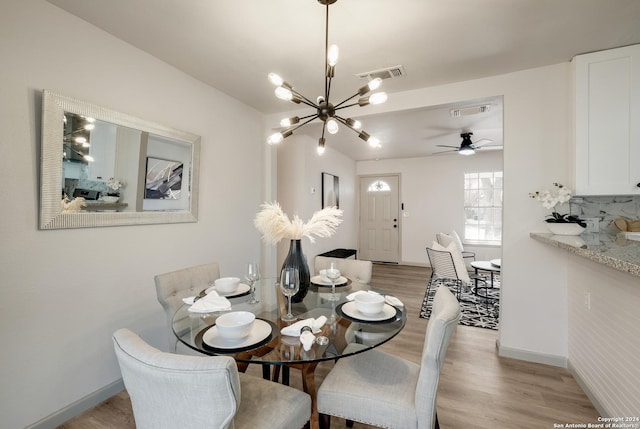 dining area with ceiling fan with notable chandelier and light wood-type flooring