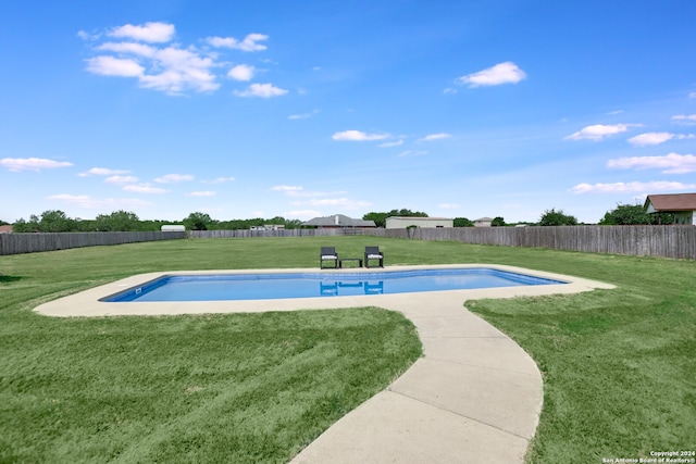 view of swimming pool with a yard