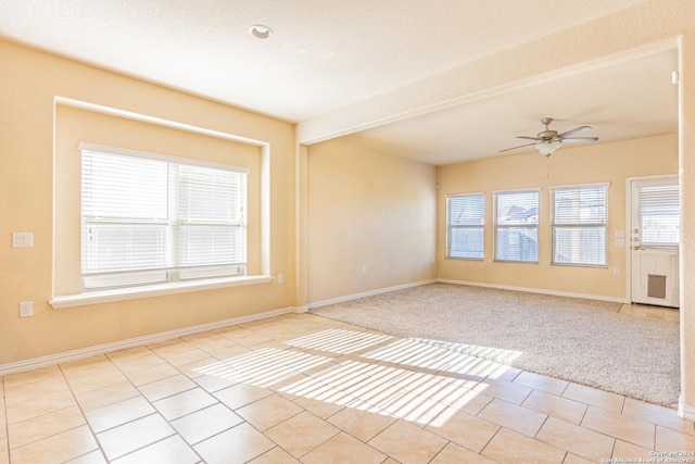 unfurnished room with beamed ceiling, light tile patterned floors, a textured ceiling, and ceiling fan