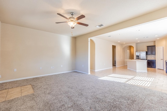 unfurnished living room featuring ceiling fan and light tile patterned flooring