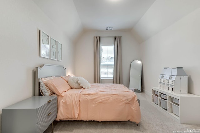 bedroom with light colored carpet and lofted ceiling