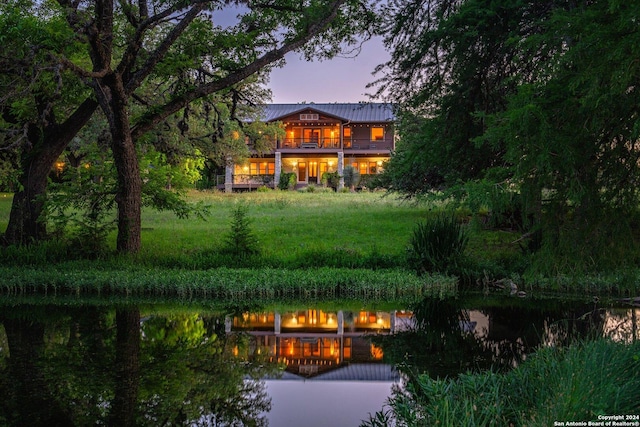 back house at dusk with a balcony