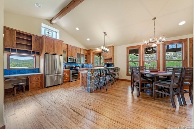 kitchen featuring tasteful backsplash, pendant lighting, beamed ceiling, and stainless steel appliances