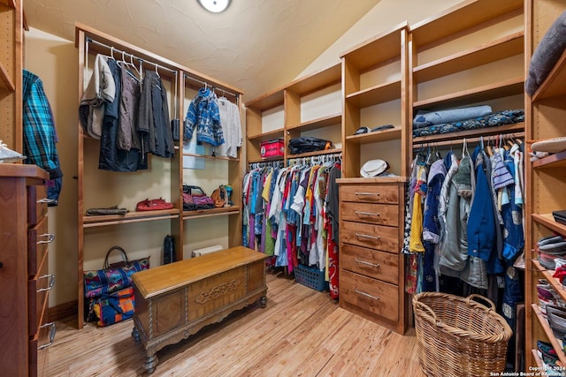 spacious closet featuring light wood-type flooring and vaulted ceiling