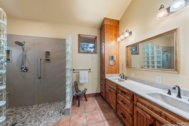 bathroom with tile patterned floors, vanity, and a tile shower