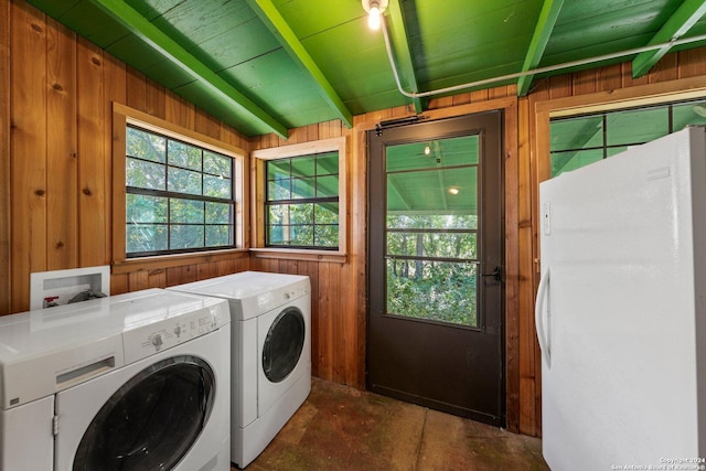 washroom with wooden walls and washer and clothes dryer