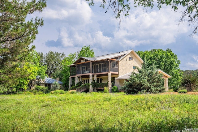 rear view of house featuring a sunroom